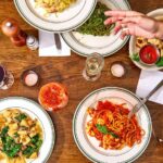 Aerial view of dining table with carbonara, ragu bolognese, and chitarra