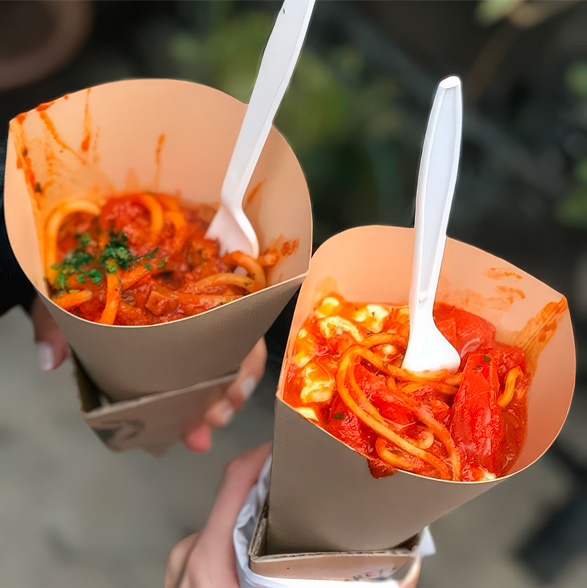 Two spaghetti cones with disposable forks sticking out of them